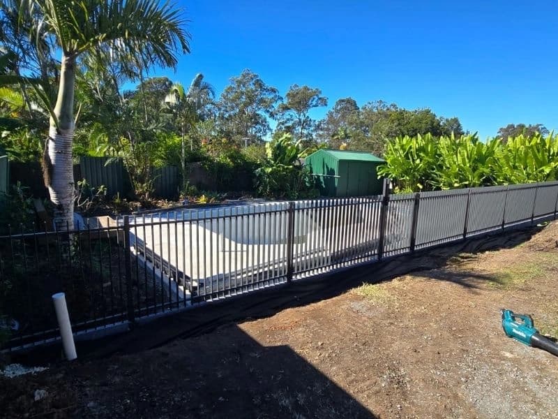 Black aluminium pool fence around a new in-ground pool